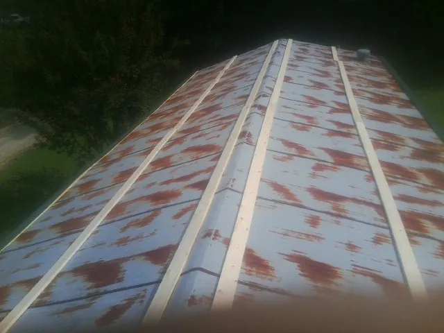 Rusted metal roof panels with new wood purlins before replacement — Storm Damage Roof Repair in Wakarusa by Roofing Brothers