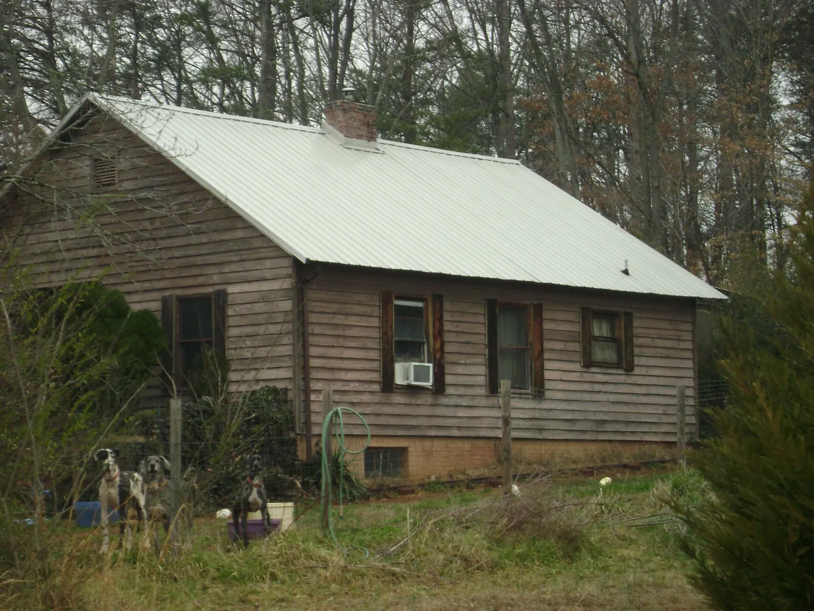 White metal roof on an old wood sided farmhouse, from a Metal Roof Installation job in Wakarusa